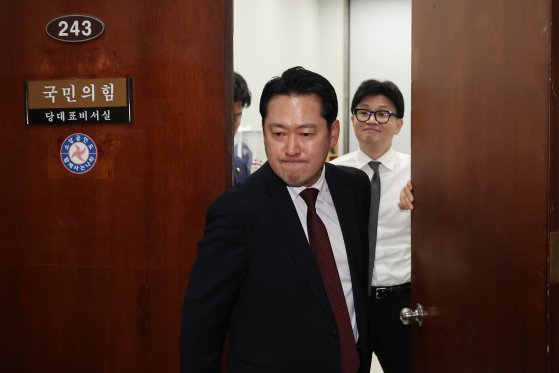 지난해 12월 11일 국민의힘 한동훈 전 대표가 당대표실에서 장동혁 의원이 나가는 사이 미소를 짓고 있다. 연합뉴스