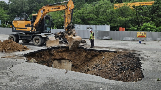 광주광역시 전 지역에 호우경보가 발효된 지난 17일 광주 동구 지산동 한 호텔 도로에서 대형 싱크홀이 발생해 도로가 통제되고 있다. 사진 독자, 연합뉴스