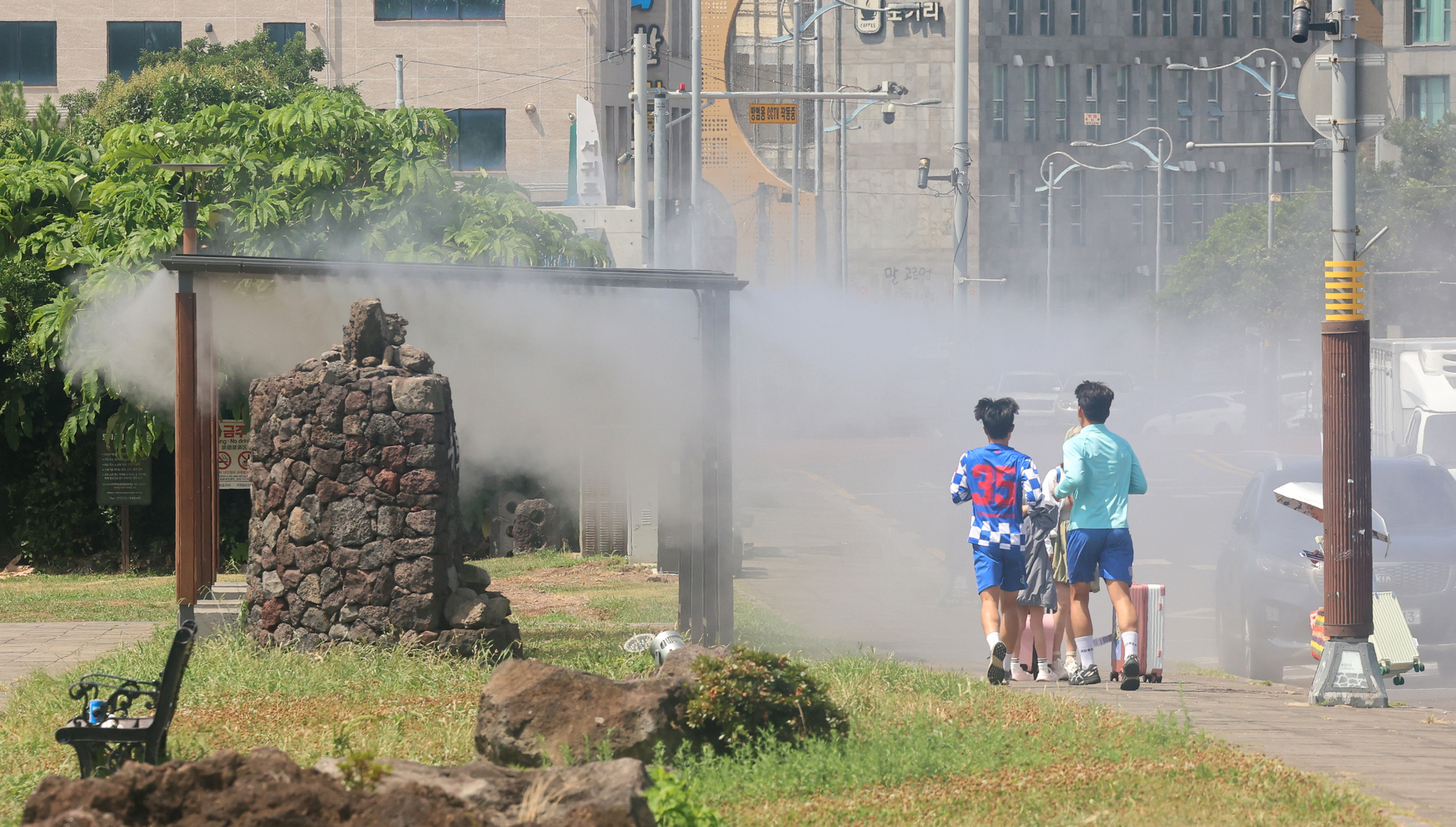 제주도 해안에 폭염주의보가 내려진 18일, 서귀포시 자구리공원에 설치된 쿨링포그 폭염쉼터에 사람들이 오가고 있다. 연합뉴스