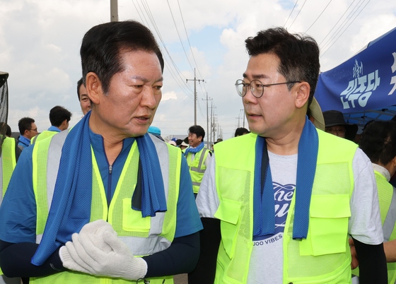 정청래(왼쪽), 박찬대 더불어민주당 당대표 후보가 21일 충남 예산 신안면 조곡리에서 수해복구 현장을 찾아 대화하고 있다. 뉴스1