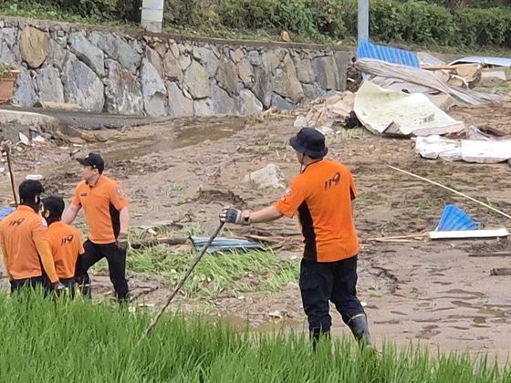 21일 오전 경남 산청군 모고리 모고마을 아래 논밭에서 한 소방대원이 나무 막대기를 들고 수색 작업을 벌이고 있다. 안대훈 기자