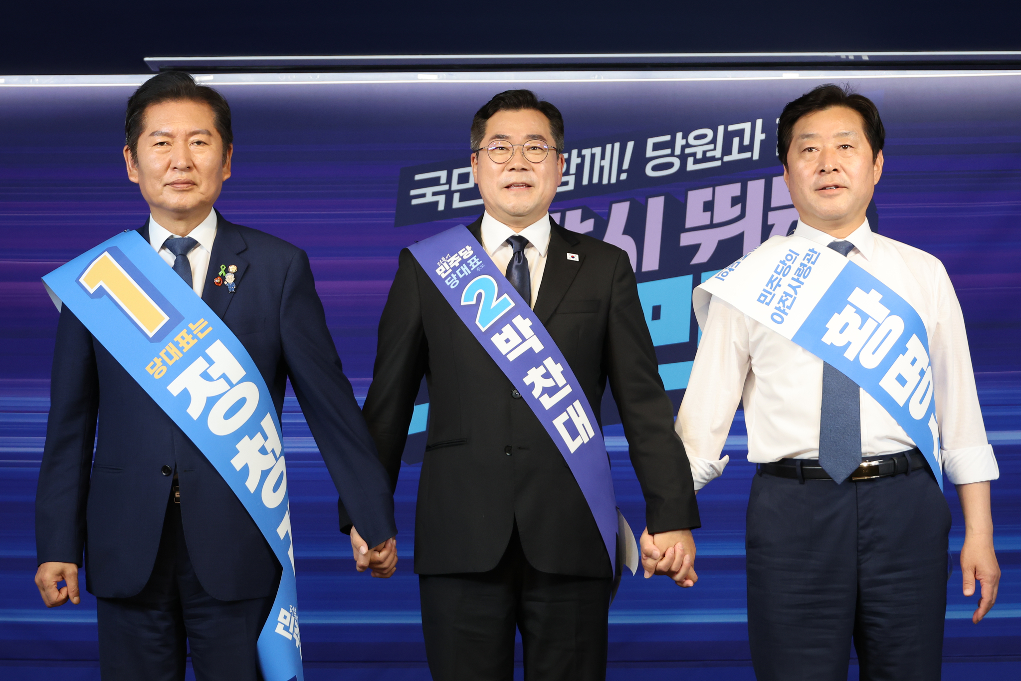 더불어민주당 정청래·박찬대(가운데) 당대표 후보, 황명선 최고위원 후보(오른쪽)가 지난 20일 서울 여의도 당사에서 열린 8·2 전당대회 순회 경선 영남권 합동연설회에서 손을 잡고 인사하고 있다. 연합뉴스