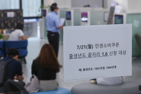 '민생회복 소비쿠폰' 신청이 시작된 21일 서울 시내 한 은행에 관련 창구가 마련돼 있다.   신청 첫 주인 21~25일에는 시스템 과부하와 주민센터 혼잡 방지를 위해 출생 연도 끝자리 기준 요일제를 운영한다. 연합뉴스