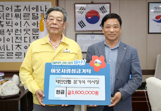 충남 태안신협 문기석 이사장(오른쪽)이 태안군청을 찾아 가세로 군수에게 성금을 기탁하고 있다. [사진 태안군]