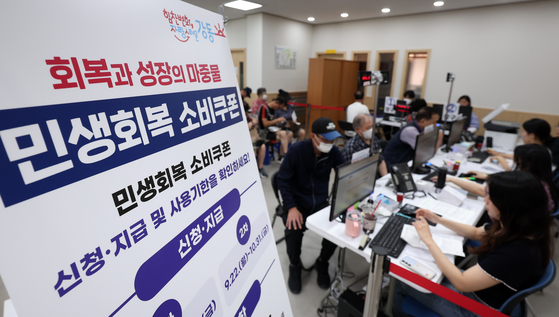 지난 22일 서울 강동구 암사 1동 주민센터를 찾은 시민들이 소비쿠폰을 신청하고 있다. 뉴스1