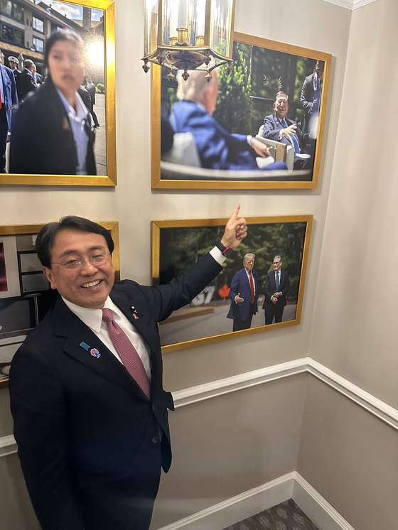 지난 22일(현지시간) 미국 워싱턴DC 백악관에서 아카자와 료세이 일본경제재생담당상이 미일 관세 협상을 마무리짓고 백악관에 걸린 이시바 시게루 총리와 도널드 트럼프 미국 대통령의 사진을 가리키고 있다. 아카자와 료세이 X(옛 트위터) 캡처