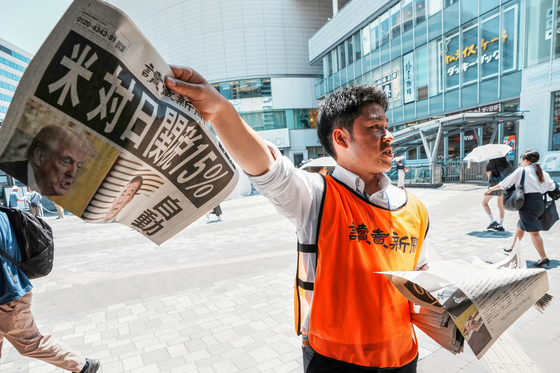 미국과 일본의 무역협상이 타결된 23일 일본 도쿄에서 요미우리신문사의 한 직원이 ‘미국, 일본에 15% 관세’라는 제목의 기사가 실린 신문 호외판을 배포하고 있다. 미국은 일본에 대한 상호관세를 25%에서 15%로 낮추고 일본은 5500억 달러(약 760조원)의 대미 투자를 약속했다. [AP=연합뉴스]
