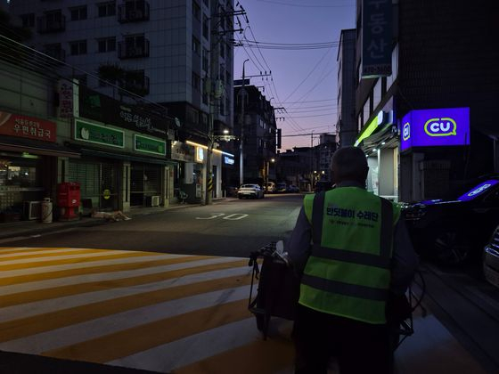 지난 24일 오전 4시30분쯤, 어두컴컴한 강동구 길동 골목길에서 김모(74)씨가 폐지를 가득 실은 손수레를 끌고 있다. 오소영 기자