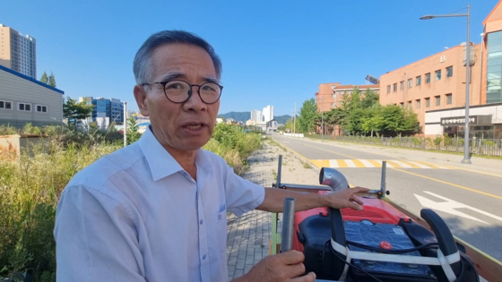 지난 24일 장석수씨가 충북 청주시 월오동 도로에서 자신이 개발한 주행형 스팀 잡초 살초기 성능을 시연하고 있다. 사진 장석수씨