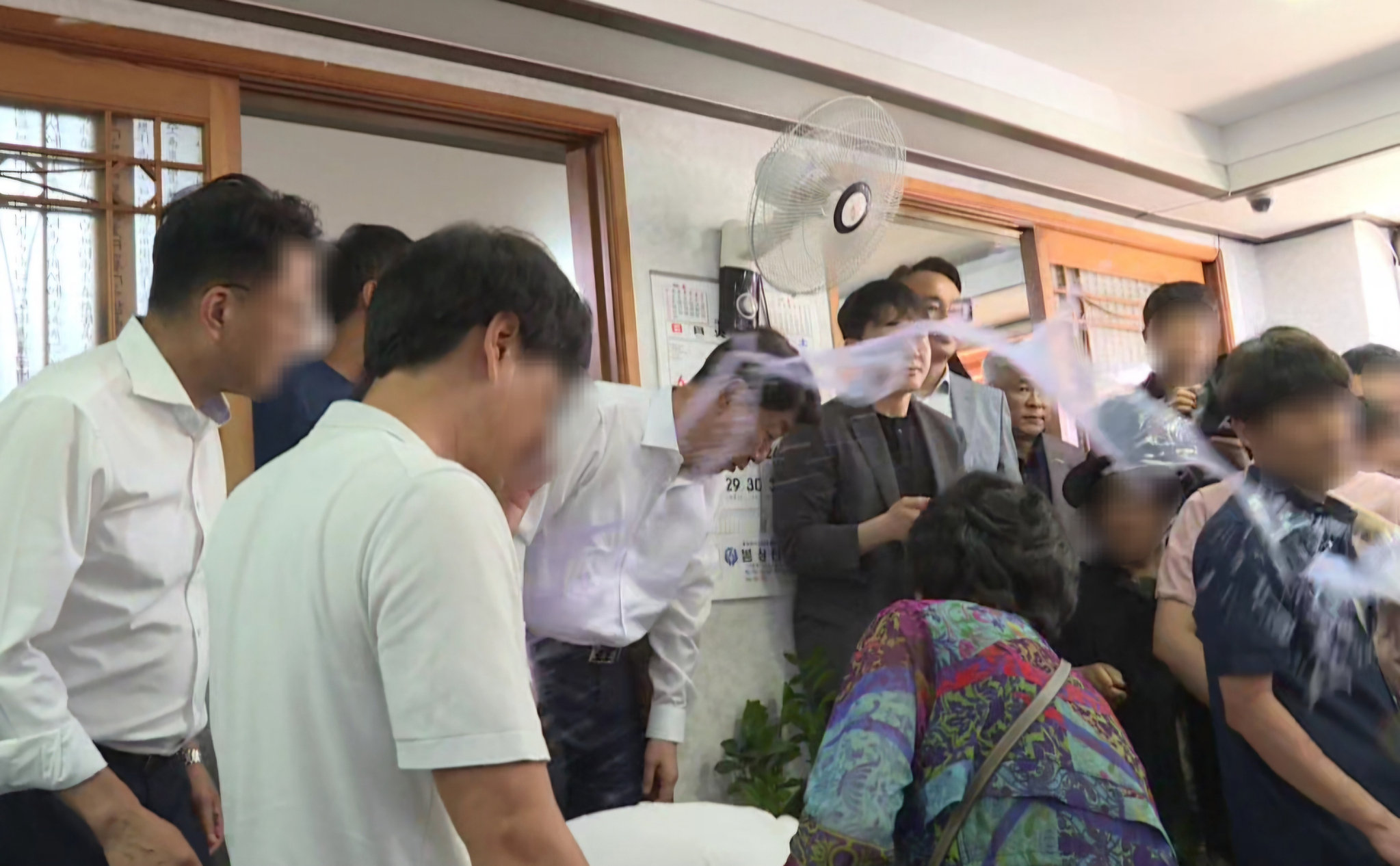 우범기 전주시장이 지난 25일 완주군 봉동읍 생강골 전통시장 내 한 식당에서 통합 찬성 단체 회원 10여명과 오찬 간담회를 하는 데 대해 통합 반대 측 군민 10여명이 항의하는 도중 한 군민이 컵에 있던 물을 우 시장 얼굴에 끼얹고 있다. 사진 독자