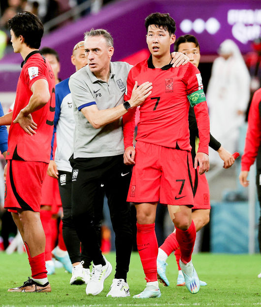   [OSEN=알 라이얀(카타르), 박준형 기자] 파울루 벤투 감독이 이끄는 축구대표팀은 28일(이하 한국시간) 카타르 알 라이얀의에듀케이션 시티 스타디움에서 카타르 월드컵 H조 조별리그 2차전 가나와 맞대결을 펼쳐서 난타전 끝에 2-3으로 패했다.앞선 우루과이 상대로 0-0 무승부에 그친 한국은 잡아야 했던 가나 상대로 패배하면서 1무 1패로 조별리그 최하위로 떨어졌다. 한국은 3차전서 포르투갈과 맞붙는다.경기종료 후 벤투 감독이 손흥민을 다독이고 있다. 2022.11.28 / soul1014@osen.co.kr