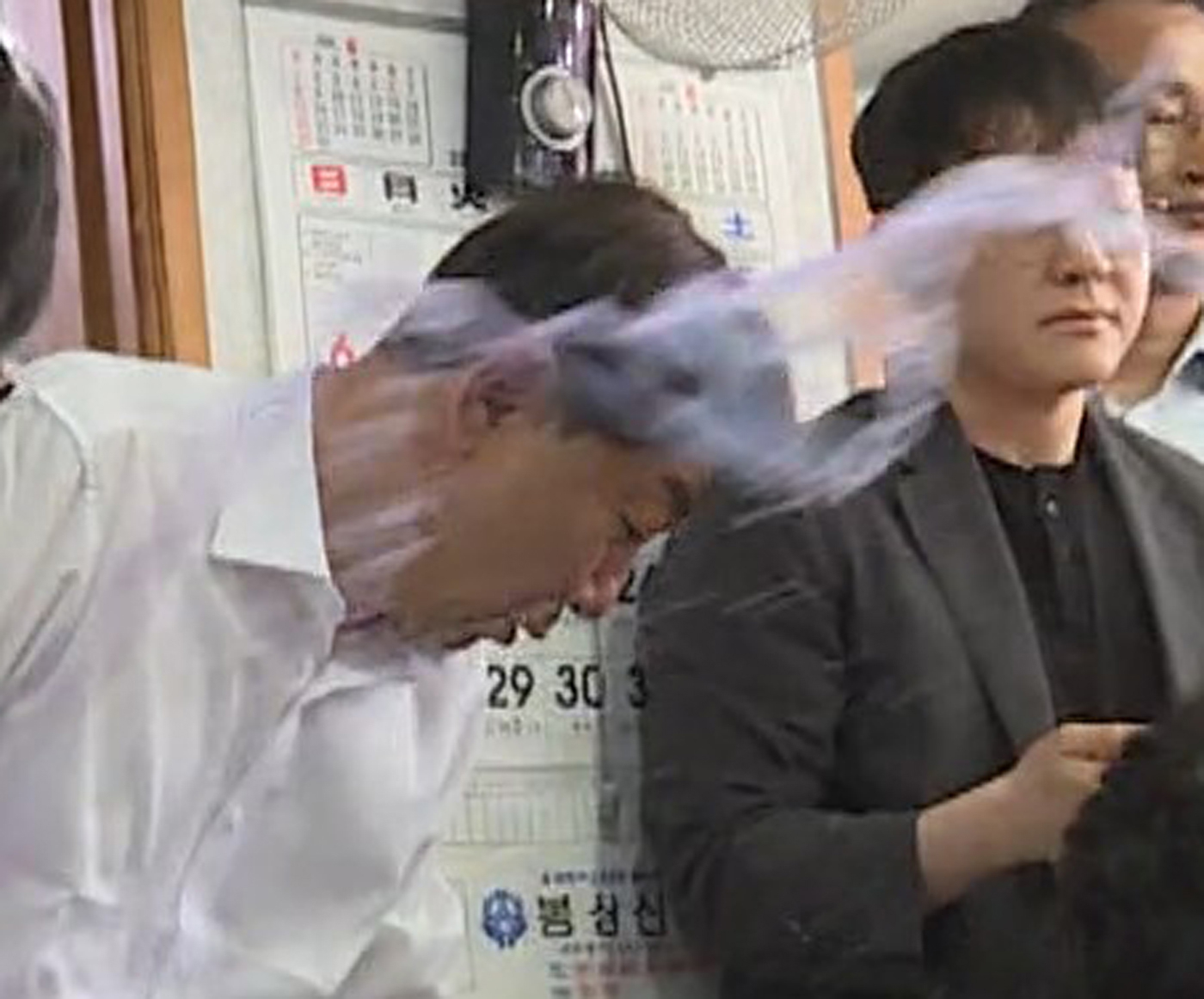 전북 전주와 완주 통합을 위해 외연 확장에 나선 우범기 전주시장이 25일 오전 11시 50분쯤 완주군 봉동의 한 식당에서 통합 반대 군민으로부터 ‘물벼락’을 맞고 있다. 사진 독자