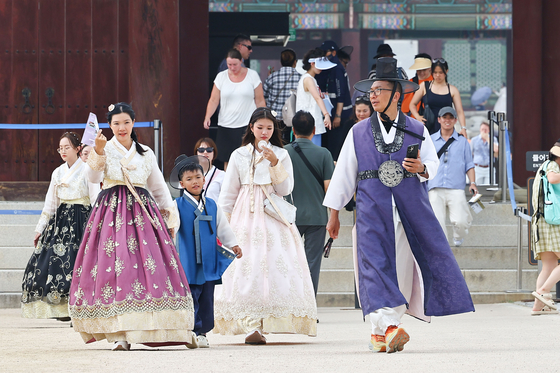 지난 7일 서울 종로구 경복궁에서 손 선풍기를 든 외국인 관광객들이 더위를 식히고 있다. 김종호 기자