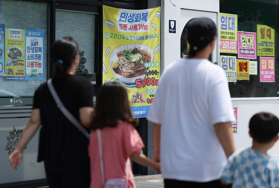 지난 27일 경북 경산시 한 상가에 소비쿠폰 사용처란 안내 현수막이 붙어 있다. 연합뉴스 