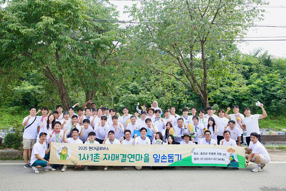 현대글로비스 임직원들이 지난 24일 홍천군 자은2리에서 진행한 1사1촌 자매결연마을 일손돕기를 기념하여 사진촬영을 하고 있다. 사진 현대글로비스