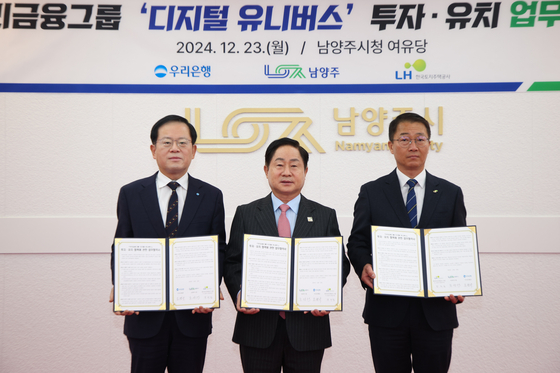 주광덕 남양주시장(가운데)과 조병규 우리은행장(왼쪽), 장희철 LH(경기도시주택공사) 남양주사업본부장이 지난해 12월 23일 남양주시청에서 디지털 유니버스 투자유치 업무 협약을 체결한 뒤 기념 촬영을 하고 있다. 사진 남양주시