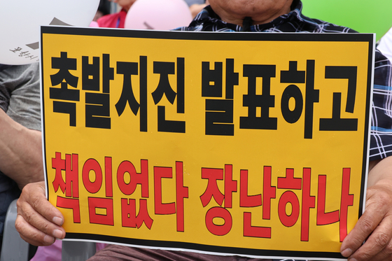 경북 포항지진 정신적 손해배상 소송의 항소심 패소 판결과 관련해 포항지진 범시민대책본부(범대본, 의장 모성은)가 지난달 13일 포항 육거리 인근 중앙상가에서 개최한 시민궐기대회에서 시민들이 항의 손팻말을 들고 있다. 연합뉴스