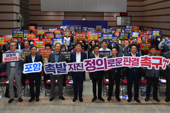 지난달 12일 경북 포항시청 대회의실에서 열린 포항지진 대시민 토론회에 앞서 참석자들이 대구고법 항소심 기각 판결 항의하는 구호를 외치고 있다.   뉴스1