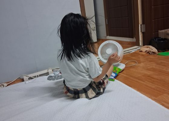무더운 밤에 잠들기 위해 일부러 물놀이한 뒤 미니 선풍기 앞에 앉은 6살 여아. 어머니 권모씨는 ″그래도 밤마다 일어나서 덥다고 보챈다″고 했다. 사진 권모씨
