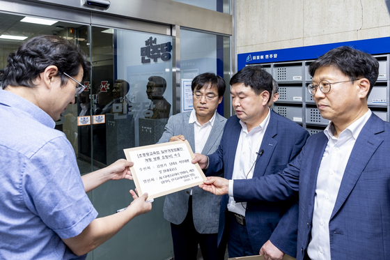지난 29일 서울 영등포구 민주당사 정문에서 한국교과서협회와 AI 교과서 주요 발행사 관계자들이 공동 입장문을 전달하고 있다. 사진 AIDT 발행사 제공