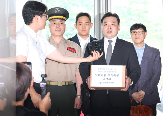 채 해병 사망 사건 초동조사 당시 수사외압을 폭로했던 박정훈 해병대 수사단장(대령)과 변경식 변호사 등이 31일 서울 서초구 순직해병특검 사무실에 참고인 신분으로 출석하며 '항명 등 사건 증인들에 대한 모해위증 수사촉구 의견서' 를 들고 취재진의 질문에 답변하고 있다. 연합뉴스