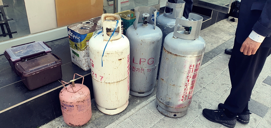 LPG 가스통 7대, 부탄가스, 휘발유·시너 통 등 다량의 발화물질이 고시텔 내부에서 발견됐다. 국립과학수사연구원은 폭파 시 반경 30m 이내 대규모 피해 가능성이 우려된다고 경고했다. 사진은 형사들이 수거한 가스통 일부. 중앙포토