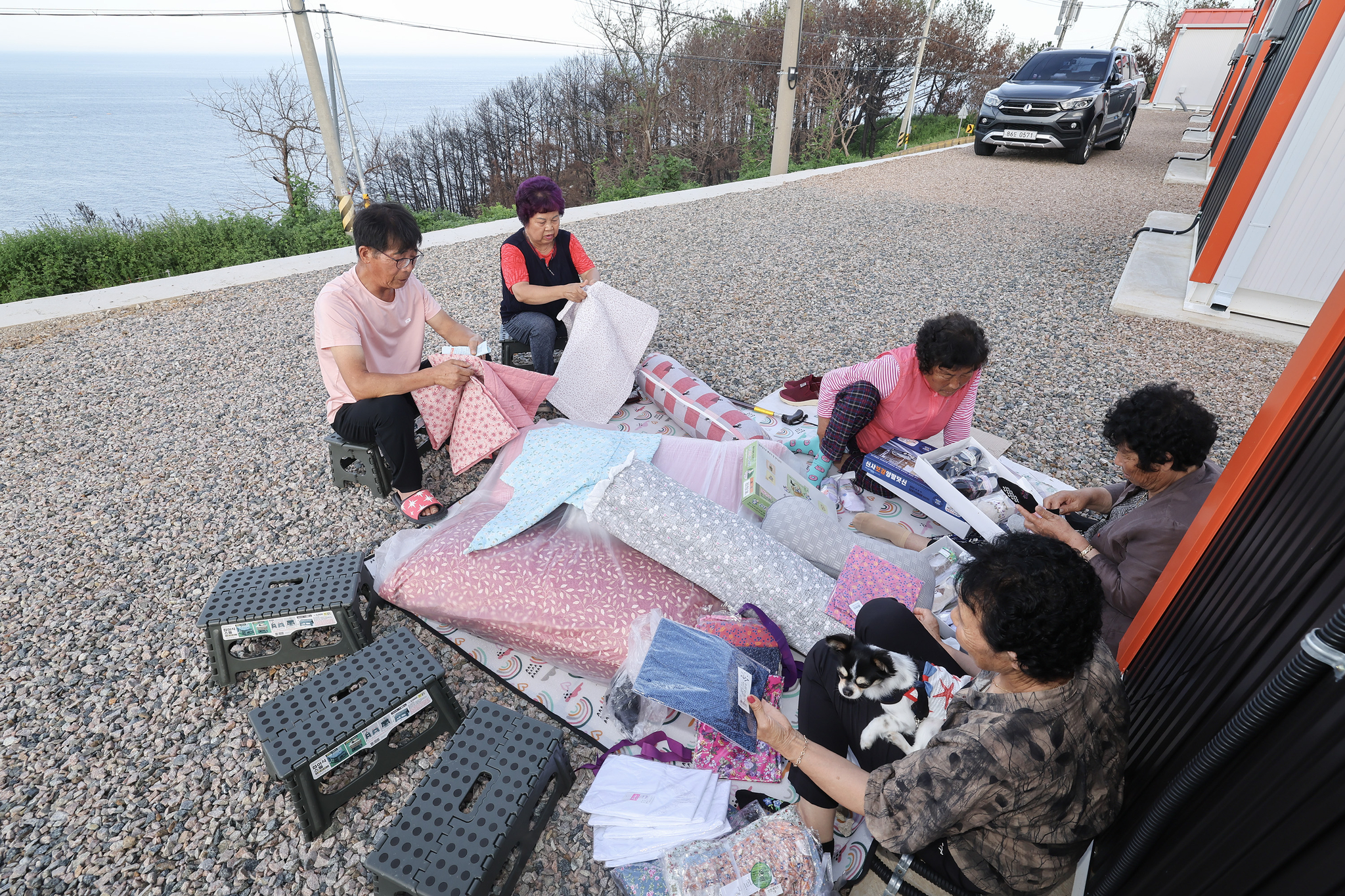 마을에 생필품을 싣고 온 상인이 오자 마을 어른들이 자리에 앉아 물건을 고르고 있다. 전민규 기자 