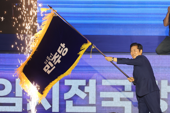 2일 경기 고양시 킨텍스에서 열린 제2차 임시전국당원대회에서 더불어민주당 대표로 선출된 정청래 신임 대표가 당 기를 흔들고 있다. 임현동 기자