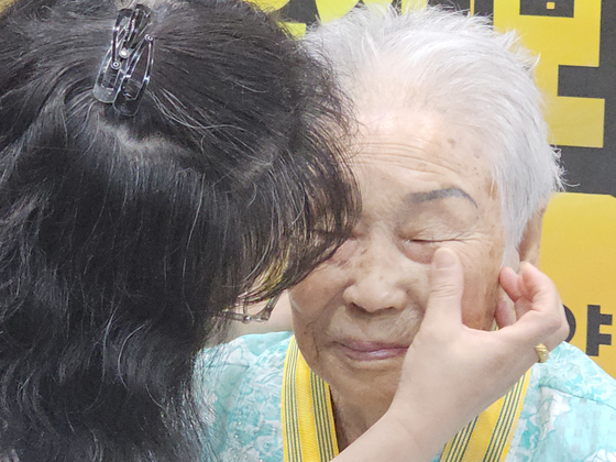 지난 2일 광주광역시 동구 한 요양병원에서 대한민국 인권상(국민훈장 모란장)을 받은 양금덕 할머니가 눈물을 흘리자 병원 관계자가 눈물을 닦아내고 있다. 뉴스1