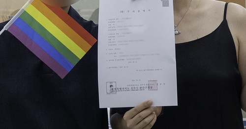 혼인신고 불수리 증명서를 들고 있는 30대 동성 커플. 사진 전북평화와인권연대