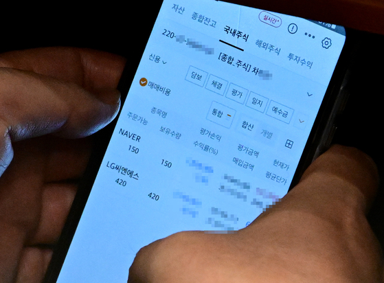 국회 법제사법위원회 위원장을 맡고 있는 이춘석 더불어민주당 의원이 4일 서울 여의도 국회에서 열린 본회의에서 타인 명의로 개설된 주식 계좌를 확인하고 있다. 사진 더팩트
