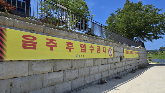지난달 9일 20대 청년 4명의 목숨을 앗아간 충남 금산군 제원면 금강 기러기공원 유원지의 한 카페 벽에 설치된 '음주 후 입수금지' 현수막. 신진호 기자 