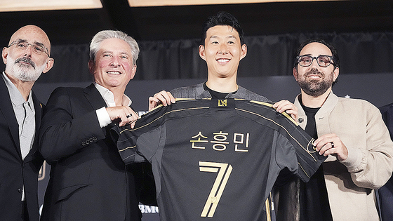  손흥민이 등번호 7번이 새겨진 LAFC 유니폼을 들고 관계자들과 기념사진을 찍고 있다. AP=연합뉴스
