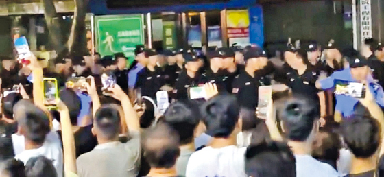 지난달 22일 중국 쓰촨성 장유시에서 발생한 10대 소녀 괴롭힘 사건의 처리에 불만을 품은 시위대들이 지난 4일 정부 청사 앞 도로에서 경찰과 대치하고 있다. 유튜브 캡처