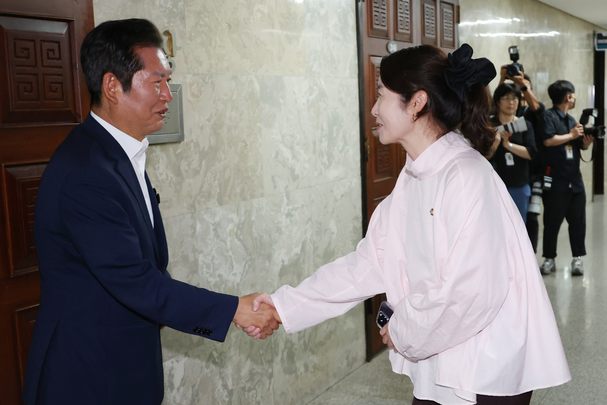 정철래 더불어민주당 대표(왼쪽)와 강선우 의원. 사진은 정 대표와 강 의원이 지난 6월 24일 서울 여의도 국회에서 열린 더불어민주당 의원총회에서 서로 악수하는 모습. 연합뉴스