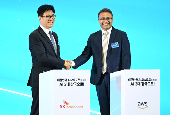 박진효 SK브로드밴드 사장(왼쪽)과 아마존웹서비스(AWS) 프라사드 칼야나라만 인프라 총괄 대표가 지난 6월 울산전시컨벤션센터에서 열린 ‘대한민국 AI 고속도로, 울산 AI데이터센터 출범식’에서 ‘SK-AWS 서명식’을 마친 뒤 악수하고 있다. [대통령실사진기자단] 
