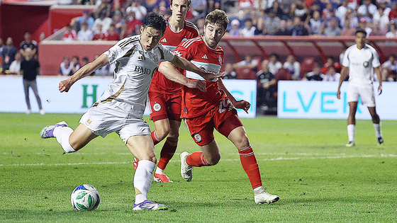  LAFC에 합류한 손흥민(왼쪽)이 입단 후 사흘 만인 10일 시카고 파이어와의 원정 경기에 후반 교체 출전해 데뷔전을 치렀다. 상대 수비진의 뒷 공간을 파고들다 페널티킥을 유도해 동점 골에 기여하며 명불허전의 경기력을 입증했다. 수비수 조너선 딘과 경합하며 슈팅하는 모습. 로이터=연합뉴스