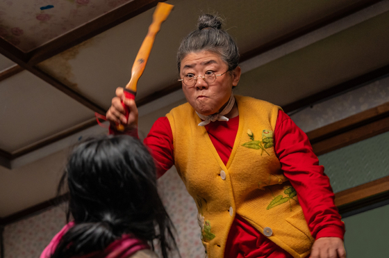 영화 '좀비딸'의 밤순(이정은)은 좀비로 변한 손녀 수아(최유리)가 입질을 할 때마다 효자 손으로 내려 친다. 사진 NEW