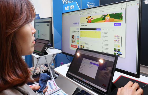 지난해 12월 인천 연수구 송도컨벤시아에서 열린 디지털 교육 페스티벌에서 한 교사가 AI 교과서를 보고 있다. 연합뉴스