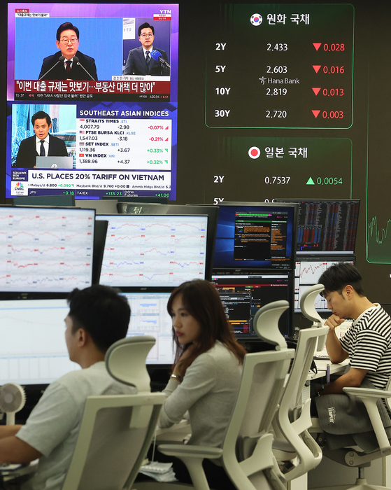 지난 3일 오후 서울 중구 하나은행 본점 딜링룸에서 오전에 있었던 이재명 대통령의 취임 30일 기자회견 뉴스가 나오고 있다.   이날 코스피는 전 거래일 종가와 비교해 41.21포인트 (1.34%) 상승한 3,116.27로 마감했다. 뉴스1