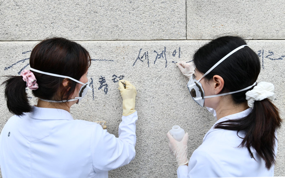 국립고궁박물관 유물과학과 관계자들이 11일 서울 경복궁 광화문 석축에 남은 낙서를 제거하고 있다. 사진 국가유산청