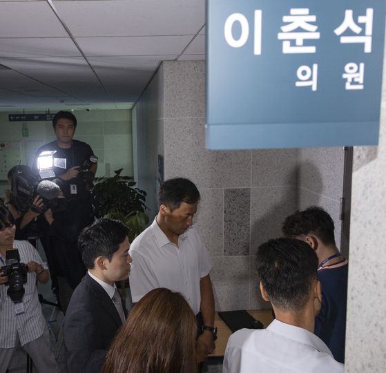 주식 차명거래 혐의를 받는 이춘석 의원의 국회 사무실에 11일 서울경찰청 금융범죄수사대 전담수사팀 관계자가 도착해 의원실 관계자와 압수수색 영장 집행을 두고 대화하고 있다. 연합뉴스