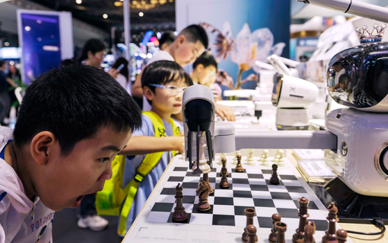 지난달 28일 중국 상하이에서 열린 ‘2025 세계인공지능대회(WAIC)’에서 관람객들이 인공지능(AI)을 상대로 체스를 두고 있다. 2017년 커제가 알파고에 패한 뒤 중국은 AI 굴기에 나섰다. [EPA=연합뉴스]
