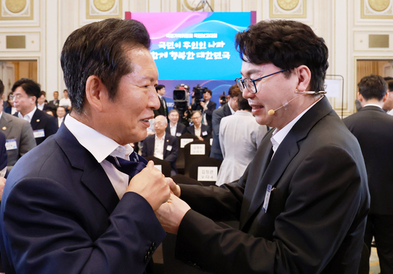 이한주 국정기획위원장(오른쪽)이 13일 청와대 영빈관에서 열린 국정위 국민보고대회에서 정청래 더불어민주당 대표의 넥타이를 풀어주고 있다. 이날 행사는 노타이로 진행됐다. [뉴시스]