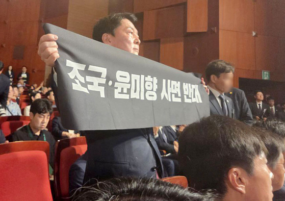 국민의힘 당권 주자인 안철수 의원이 15일 오전 서울 종로구 세종문화회관에서 열린 제80주년 광복절 경축식에 참석해 경축사 중인 이재명 대통령을 향해 조국 전 조국혁신당 대표와 윤미향 전 의원의 사면 반대 플래카드를 들어보이며 항의하고 있다. 뉴스1