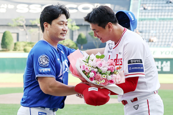 지난 7일 SSG와의 원정 경기에서 후배 김광현(오른쪽)으로부터 꽃다발을 받는 오승환. 뉴스1