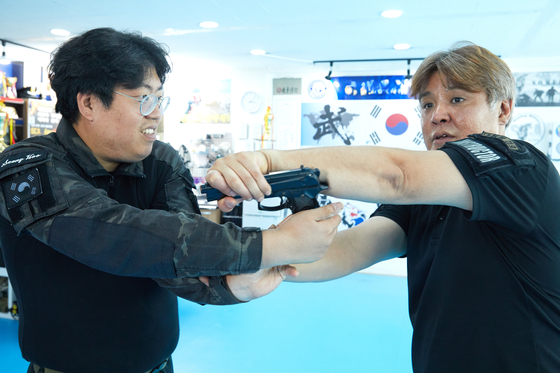총을 제압해서 뺏는 방법 등 권총 활용 기술을 시범 보이는 김대영 대표와 김성후(왼쪽) 사범.