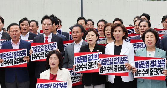 국민의힘 송언석 비대위원장 겸 원내대표 등 의원들이 18일 김건희 여사 관련 의혹을 수사하는 민중기 특별검사팀 사무실이 마련된 서울 종로구 KT 광화문빌딩 웨스트 앞에서 현장 비상의원총회를 열고 야당탄압 정치보복 압수수색 규탄 구호를 외치고 있다. 우상조 기자