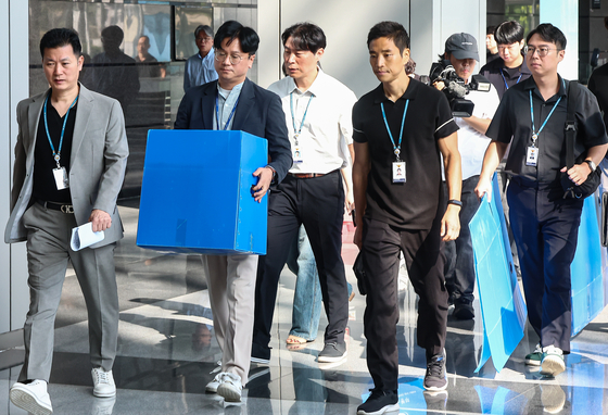 경기남부경찰청과 고용노동부 관계자들이 지난 12일 인천시 연수구 포스코이앤씨 본사 사옥에서 압수품을 담기 위한 박스를 들고 이동하고 있다. 뉴스1