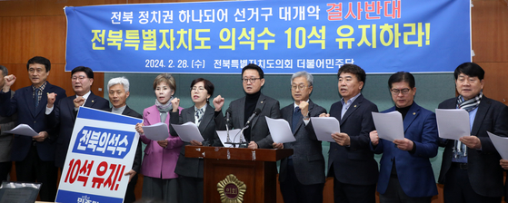 전북특별자치도의회 더불어민주당 의원들이 지난해 2월 28일 전북 전주시 전북자치도의회에서 '전북 의석 10석 사수' 기자회견을 열고 구호를 외치고 있다. 뉴스1